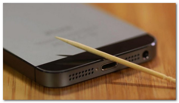 clean iphone charging port with toothpick